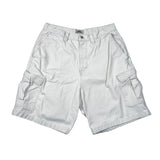 A pair of light beige cargo shorts with side flap pockets, laid flat on a white background.