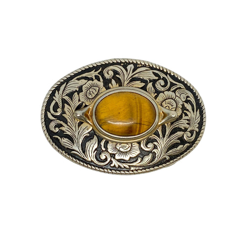 Decorative belt buckle with floral patterns and a yellow stone on a white background