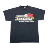 A faded black short-sleeve t-shirt featuring the Pittsburgh Steelers National Football League logo on the front, laid flat against a white background.