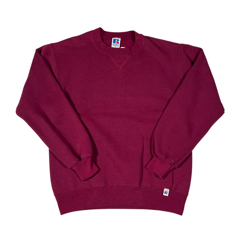 Folded maroon polo shirt with a small logo on a white background