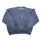 A faded dark blue crewneck sweatshirt with white paint splatters, laid flat on a white surface.