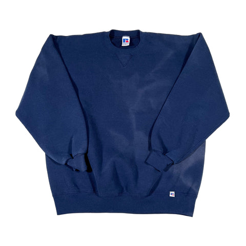 Folded blue sweatshirt with a small logo on a white background