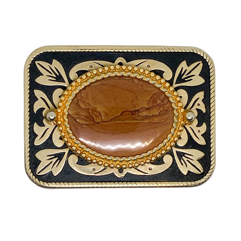 Decorative belt buckle with gold and black design on a white background
