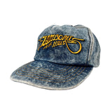 Blue denim cap with yellow embroidered text on a white background