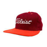 Red and orange Titleist cap on a white background