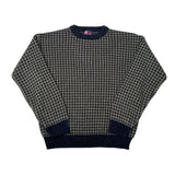 A vintage crewneck sweater featuring a fine black and beige houndstooth pattern with solid dark navy ribbed trim on the collar, cuffs, and hem.