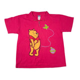 Pink polo shirt with a cartoon bear design on a white background