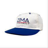 White and blue cap with ZIMA branding on a gray background