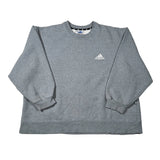 A heather gray long-sleeve crewneck sweatshirt with a small white Adidas logo on the left chest, laid flat on a white background.