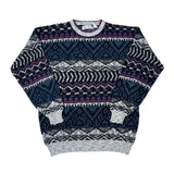 A vintage Fair Isle knit sweater with a complex geometric pattern in navy blue, purple, black, and light gray, laid flat on a white background.