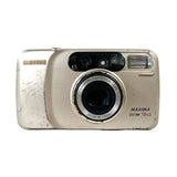 A vintage Samsung Maxima ZOOM 70 CL compact camera in a light beige or champagne color, showing signs of wear and scuffs on the front, photographed against a plain light gray background.