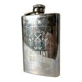 A vintage stainless steel flask with a silver screw cap and a metal clip, featuring an engraved crest and the text 'MOULINI ROUGE' on the front, set against a plain light gray background.