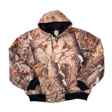 A hooded zip-up jacket with a woodland camouflage pattern in shades of brown, beige, and black, laid flat on a white background. The brand Carhartt is visible on the inner neck label and a small chest patch.