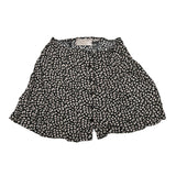 Black shorts with white floral pattern on a white background