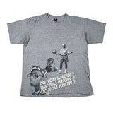 A heather gray short-sleeve t-shirt featuring a graphic collage of Michael Jordan, the text 'DO YOU KNOW ?', a 'BROOKLYN' cap, and a small pink Jumpman logo on the chest, laid flat on a white background.