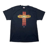 A black short-sleeve graphic t-shirt laid flat on a white background. The shirt features a central graphic of a cross made of red-orange glowing blocks, with a yellow banner across the middle reading 'TAKE THE DEAL!'.