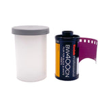 A roll of Kodak Professional BM400CN film with a purple strip unrolled, shown next to a translucent white plastic film canister with a gray lid on a white background.