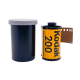 A roll of Kodak 200 film with a brown film strip partially unrolled next to its black plastic canister with a gray lid, on a white textured background.